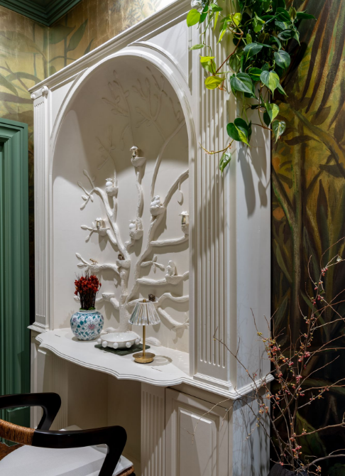 Intricate white alcove with decorative tree and interior design elements.